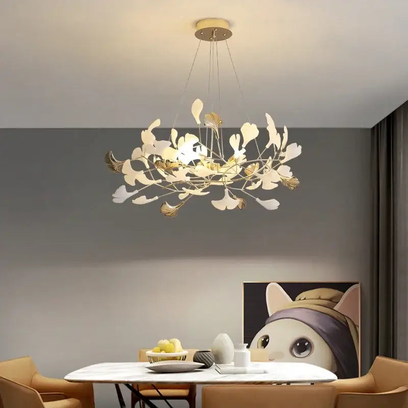 A modern decorbites ginkgo leaf chandelier pendant light with matte white and gold leaf-shaped metal arms