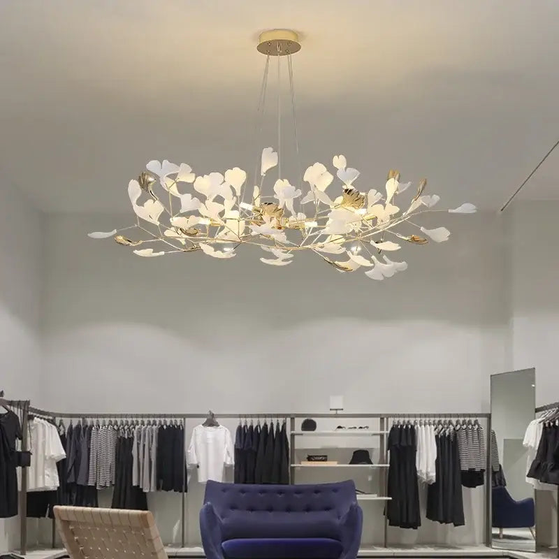 A decorbites ginkgo leaf chandelier with white and gold leaf-shaped accents suspended from a circular ceiling mount