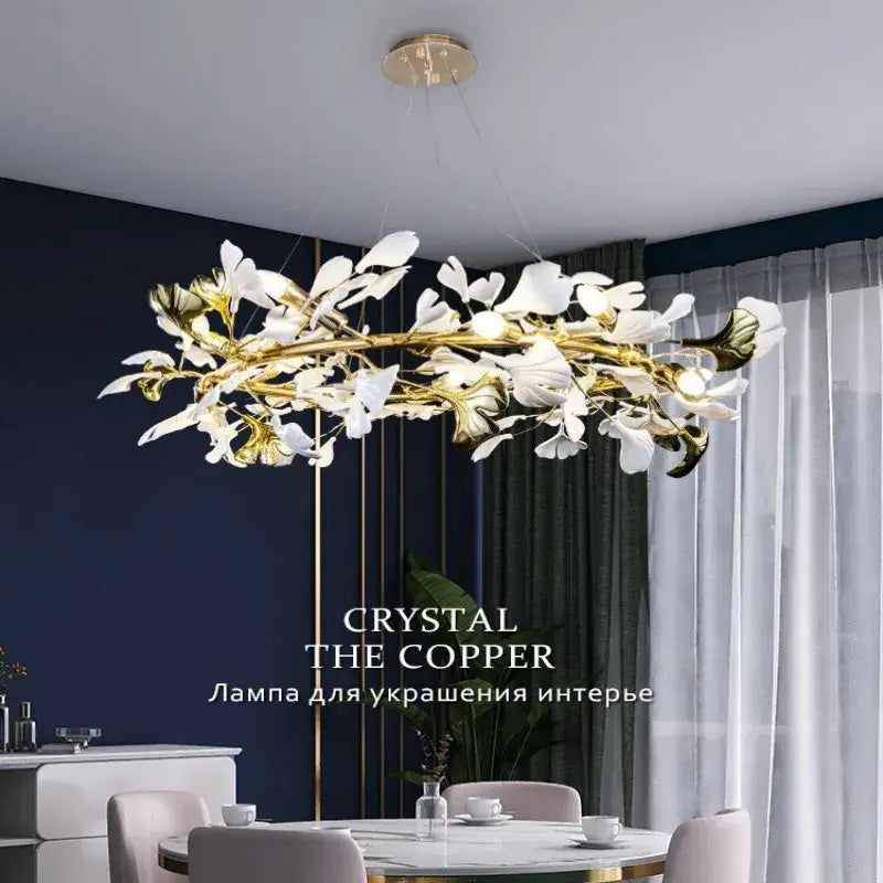 Elegant gold and white crystal chandelier with ginkgo leaf design by DecorBites featuring delicate blossoms and branches