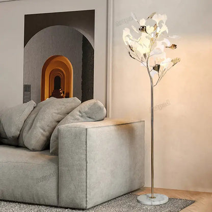Elegant gold-toned decorbites ginkgo leaf floor lamp with white and metallic leaf shades on marble base for living room