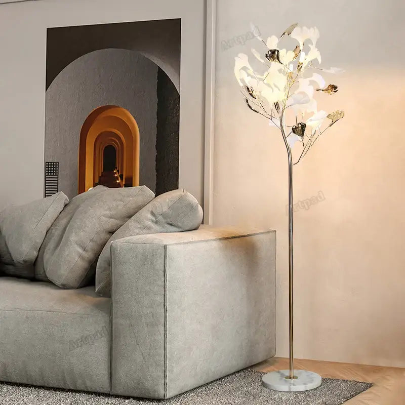 Elegant gold-toned decorbites ginkgo leaf floor lamp with white and metallic leaf shades on marble base for living room