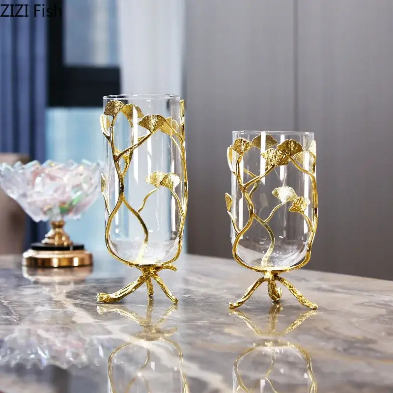 Elegant clear glass vase with intricate gold leaf ginkgo leaf detailing and a modern three-legged base for decoration