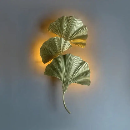 Gold-toned metallic wall lamp shaped like three overlapping ginkgo leaves with slender stem by decorbites ginkgo leaf