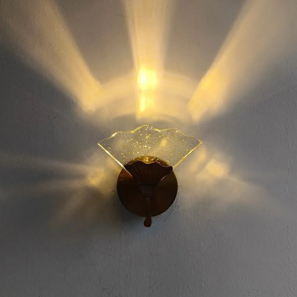 A warm amber-toned DecorBites Ginkgo Leaf wall light with a translucent speckled glass shade and elegant fan design