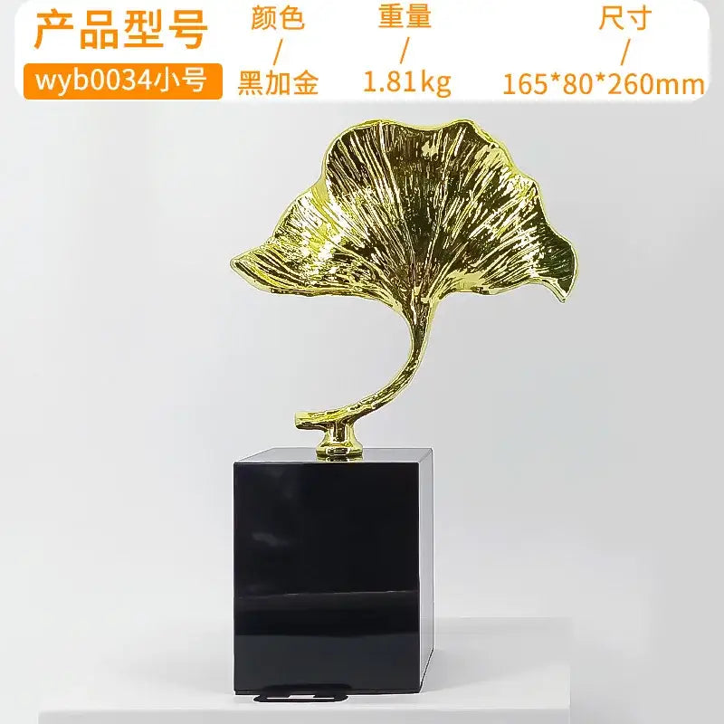 Decorbites ginkgo leaf metal sculpture featuring a glossy golden leaf mounted on a sleek black rectangular base