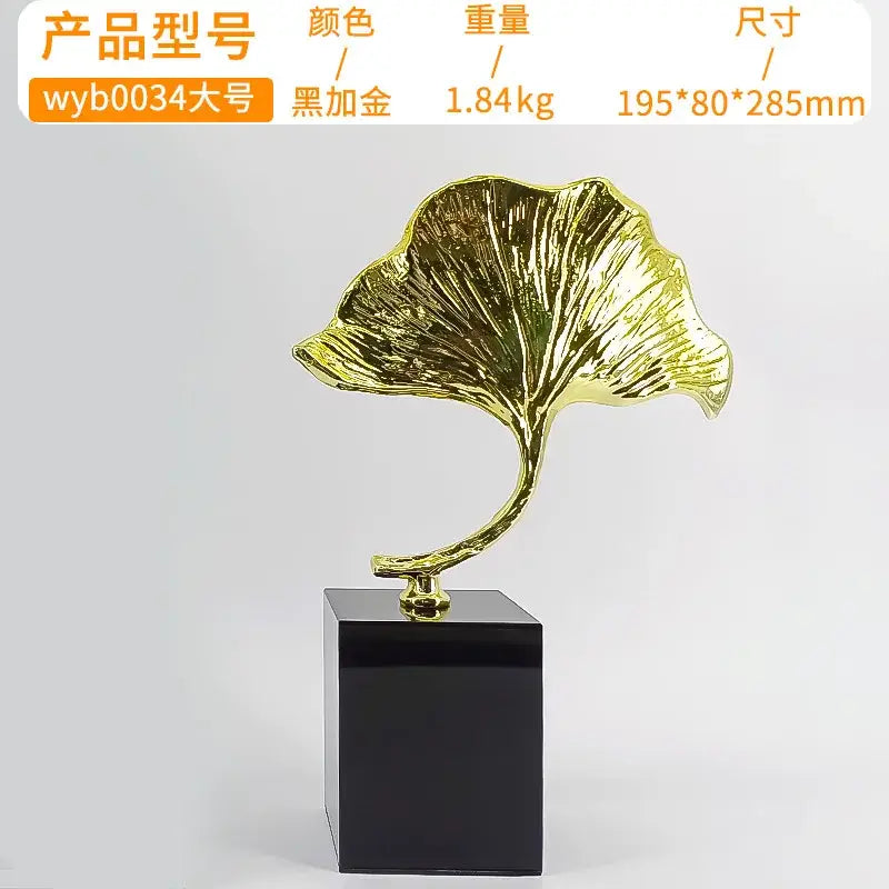 Decorbites ginkgo leaf metal sculpture in golden metallic finish mounted on black base for home decor accent