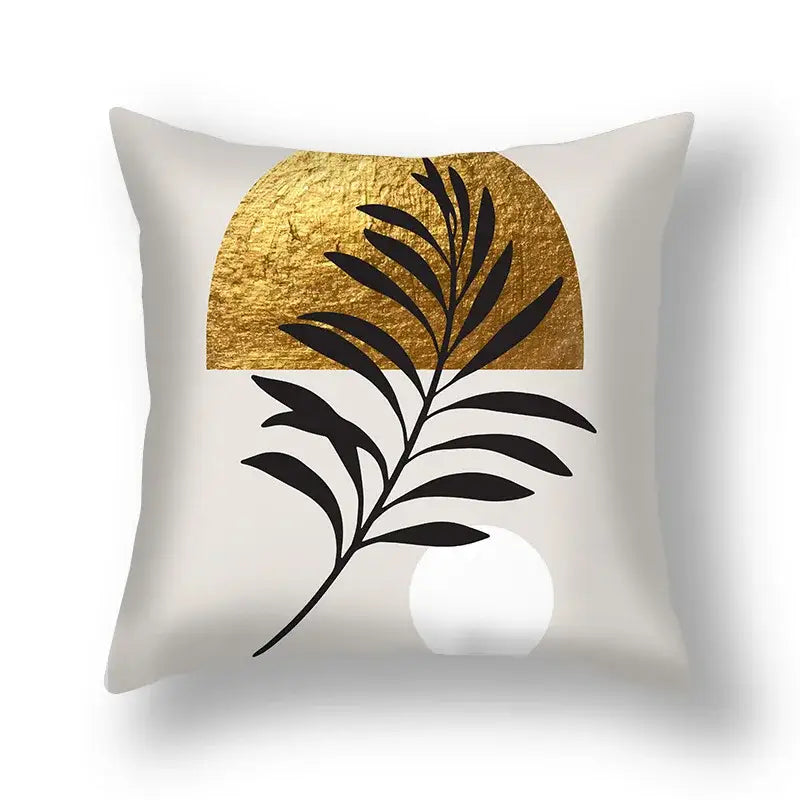White throw pillow with decorbites ginkgo leaves print featuring black leaf silhouettes on textured gold and white circles