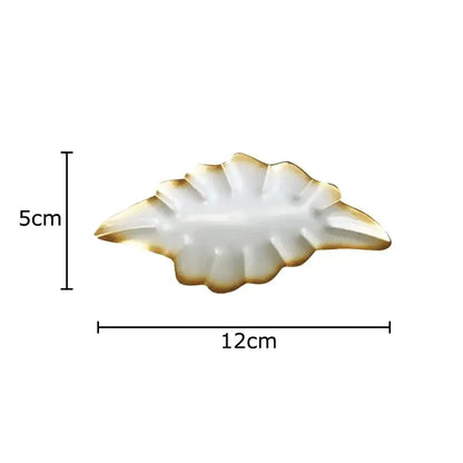 A white ceramic ginkgo leaf wall hanging ornament with gold trim from decorbites for living room decor