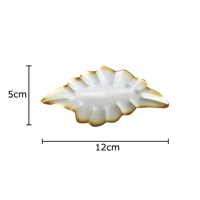 A white ceramic ginkgo leaf wall hanging ornament with gold trim from decorbites for living room decor