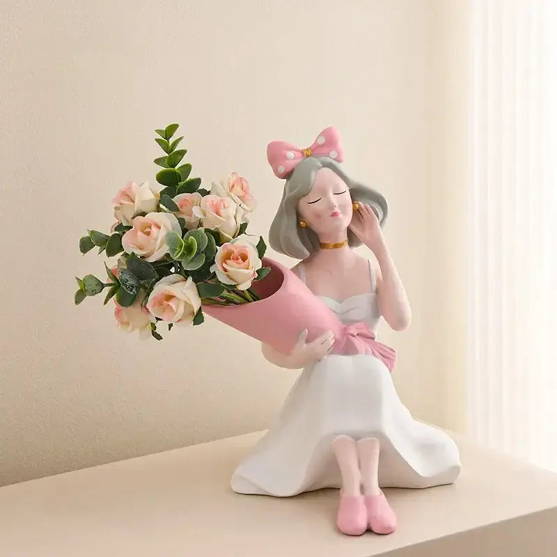 A pink and white resin decorbites girl statues vase ornament of a seated girl holding roses for office decor