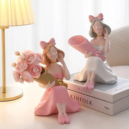 Pink resin decorbites girl statues of two seated women with bouquet and rolled paper as vase ornaments for decor