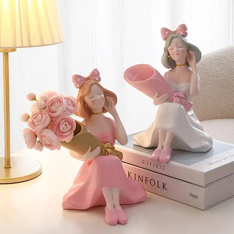 Pink resin decorbites girl statues of two seated women with bouquet and rolled paper as vase ornaments for decor