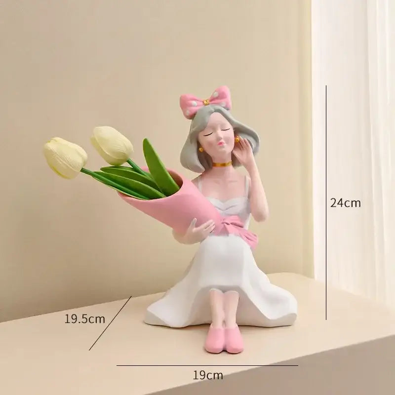 A pink and white resin decorbites girl statues figurine vase ornament of a seated girl holding yellow tulips for office decor