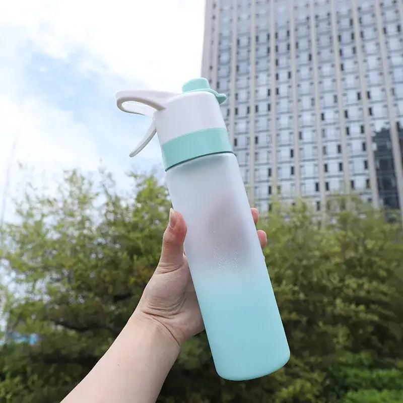 A translucent mint-green DecorBites girls 700ml spray water bottle with white and light green lid and carrying loop