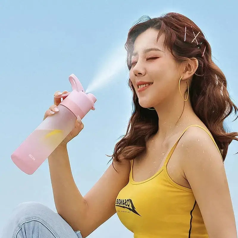 Pink translucent spray water bottle with bunny ear nozzle and subtle logo for DecorBites girls outdoor sports use