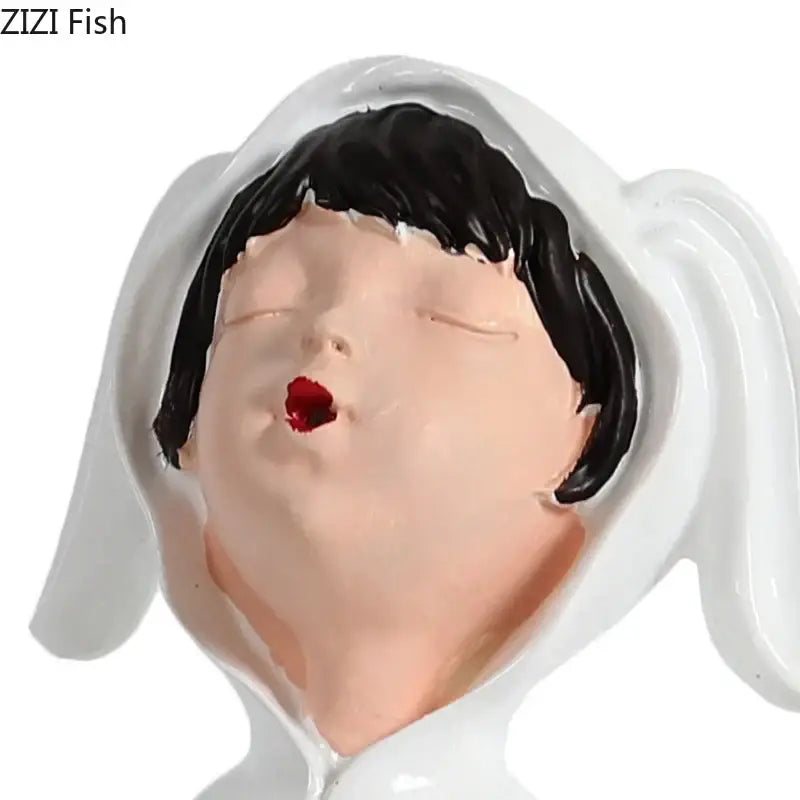 Decorbites™ resin sculpture figure of a white ceramic girl with black hair and red lips wearing a hooded garment