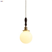 Warm-toned spherical glass pendant lamp with dark walnut wood handle and brass accents decorbites glabe led pendant