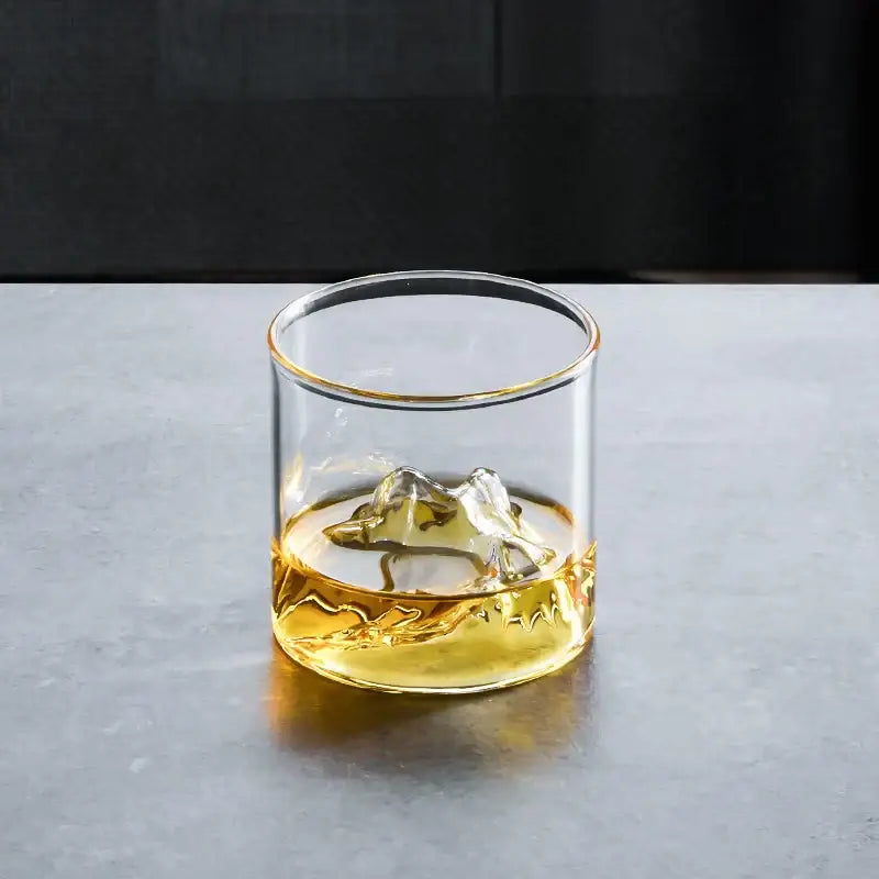 Clear glass decorbites glacier wine cup with gold rim and textured base filled with amber whisky liquid