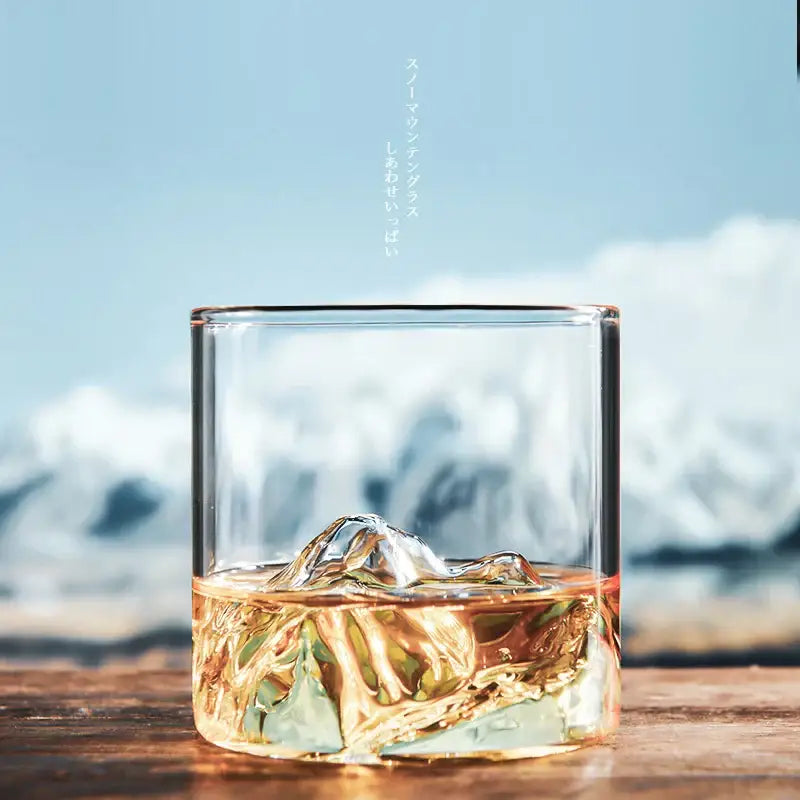 Clear glass decorbites glacier wine cup with thick base filled halfway with amber whiskey and ice cubes showing Fuji artwork