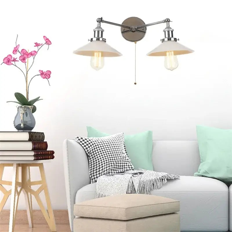 Decorbites glass 2-light wall sconce with pull chain switch features brushed nickel arms, cream shades, and exposed edison bulbs