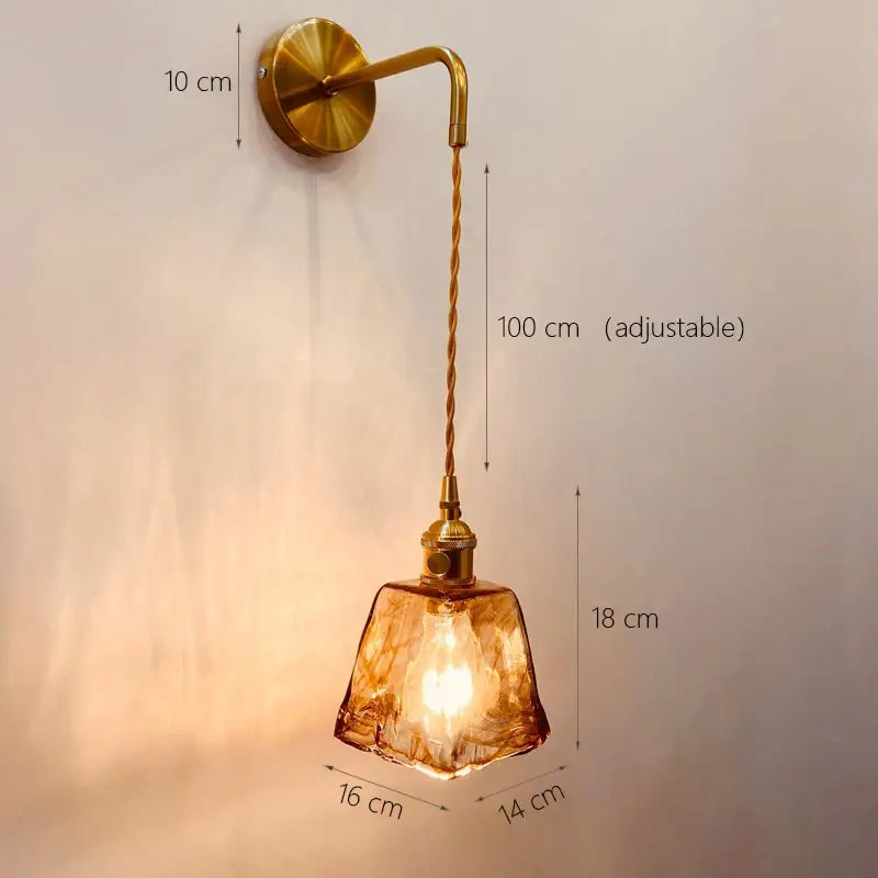 A warm amber glass adjustable led sconce wall light by decorbites with brass finish and twisted cord for bedroom decor