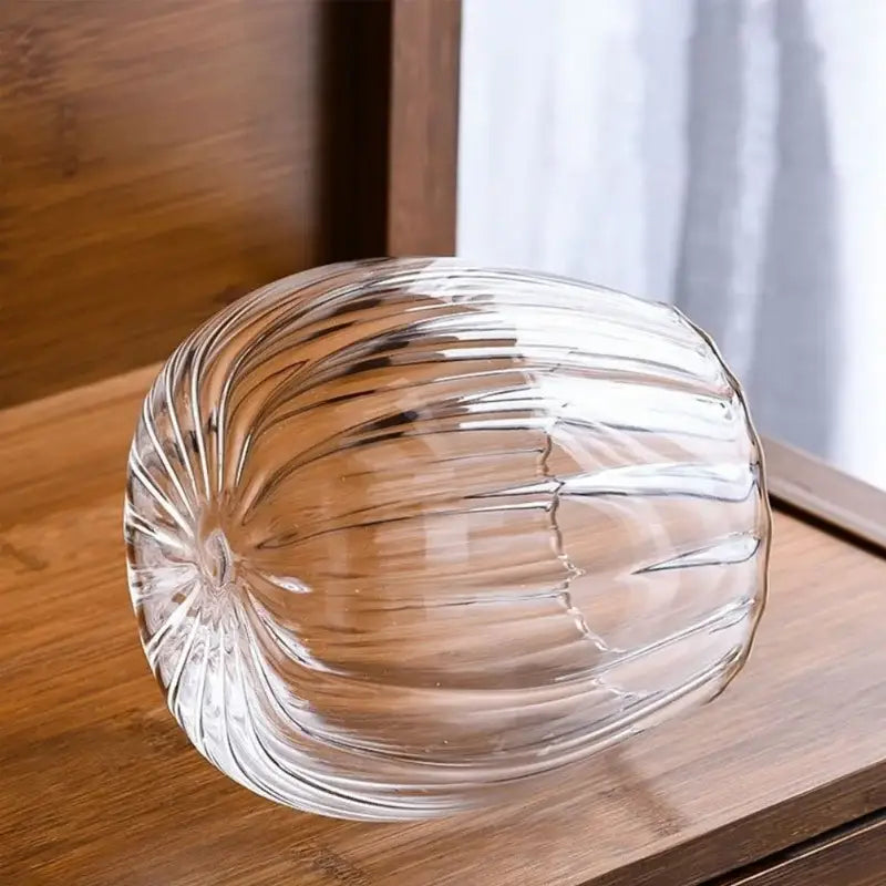 Clear glass airtight canister with ribbed pumpkin design and wooden lid by DecorBites for stylish kitchen storage