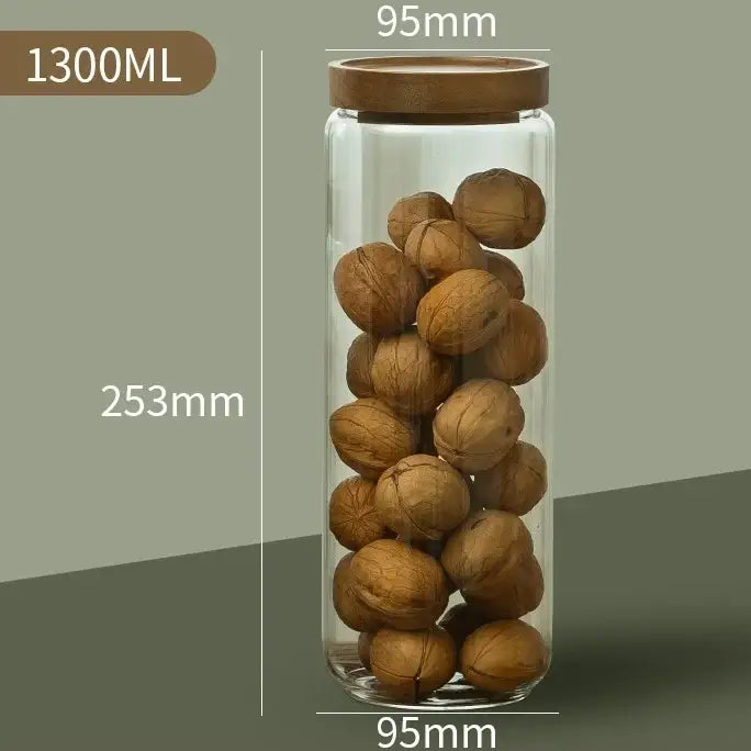 A clear decorbites glass airtight canister with a wooden lid filled with walnuts for versatile kitchen storage