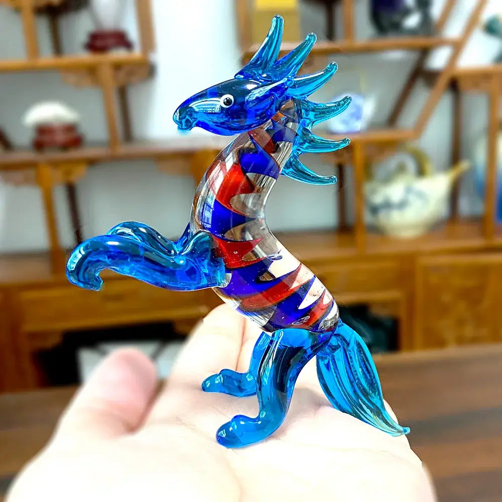 A translucent blue glass dragon figurine with red and purple swirling patterns from decorbites glass animal figurines collection