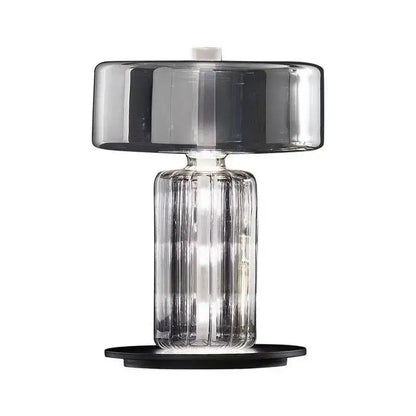 Modern decorbites glass art desk lamp with translucent gray glass shade and clear ribbed base on black platform for bedroom
