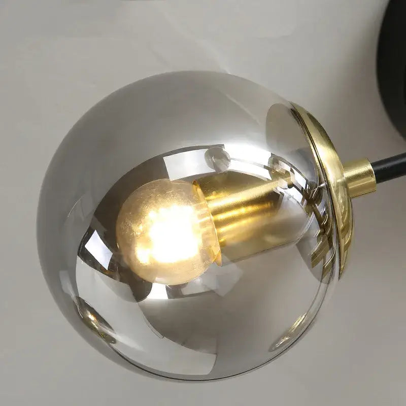 A decorbites glass ball black spherical pendant light with brushed brass fixture and exposed edison bulb for dining ceilings
