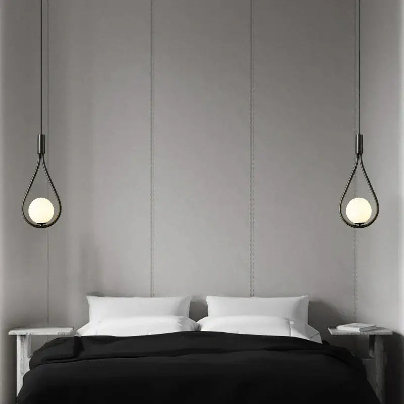 Black teardrop pendant lights with frosted glass globes hang above bed in decorbites glass ball brass wall lamp design