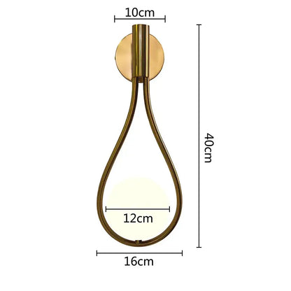 A sleek brass teardrop wall lamp with warm glowing light by decorbites glass ball brass for bedroom and living room lighting