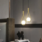Two elegant gold-toned decorbites glass ball brass wall lamps with teardrop frames and glowing bulbs for bedroom lighting