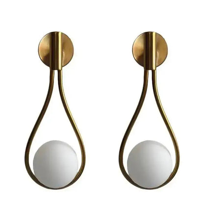 Pair of brass teardrop wall lamp sconces with white glass ball shades from DecorBites glass ball brass collection