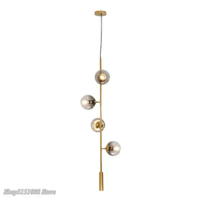 Modern brass-finished DecorBites glass ball pendant light with four frosted glass globe shades on vertical rod