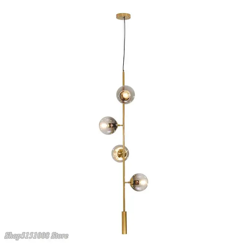 Modern brass-finished DecorBites glass ball pendant light with four frosted glass globe shades on vertical rod