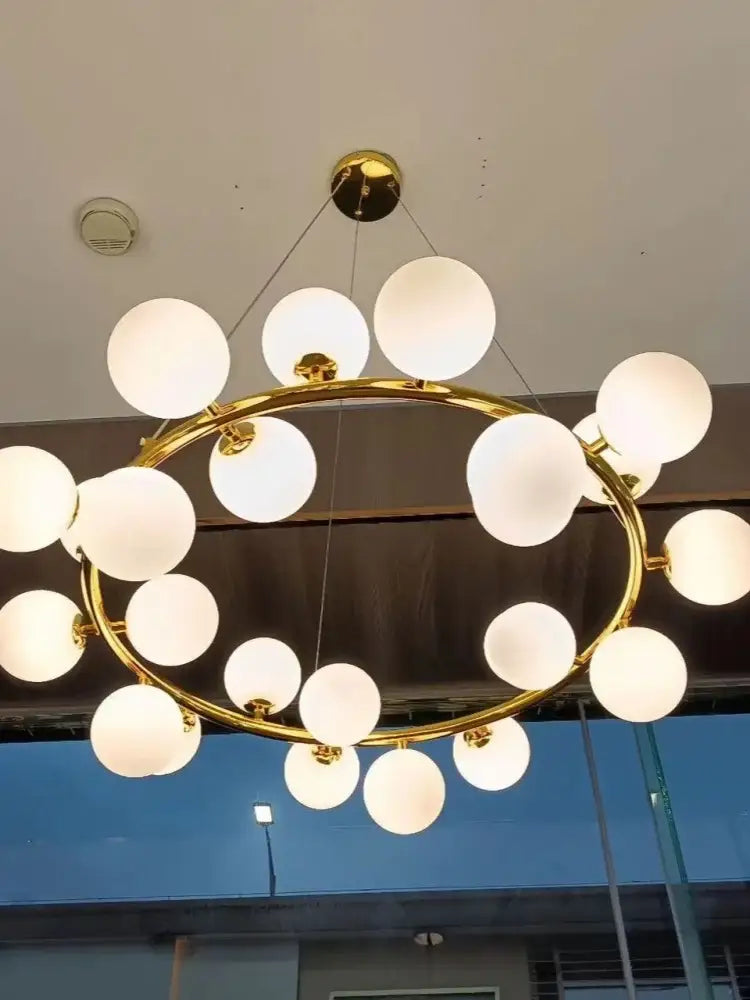 Gold-toned DecorBites glass ball ceiling chandelier with frosted white spherical globes for dining and living room decor