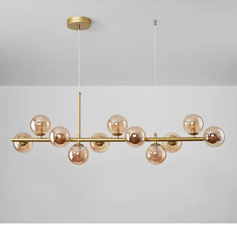 Gold-toned decorbites™ ball ceiling chandelier with amber glass globe bulbs on sleek horizontal bar for home lighting