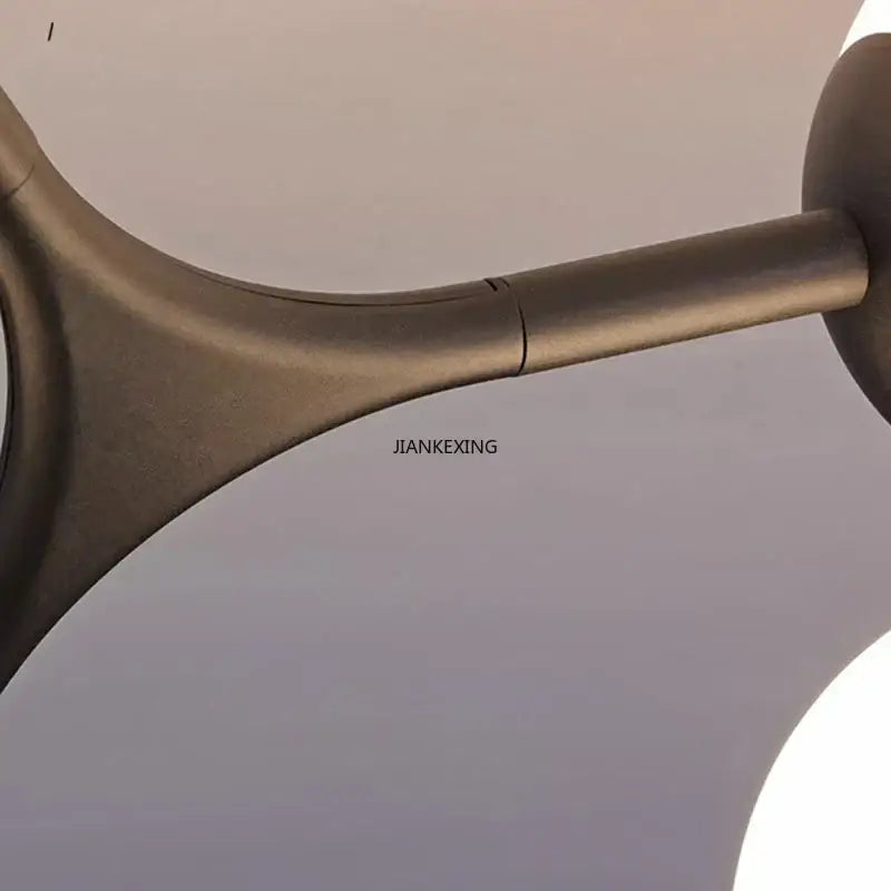 Bronze-colored metallic ceiling fan arm with sleek curved design and smooth finish in decorbites glass ball ceiling chandelier