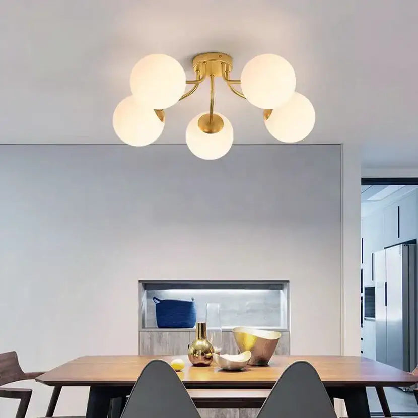 Gold-toned decorbites glass ball ceiling fixture with five frosted glass globe shades for modern bedroom lighting