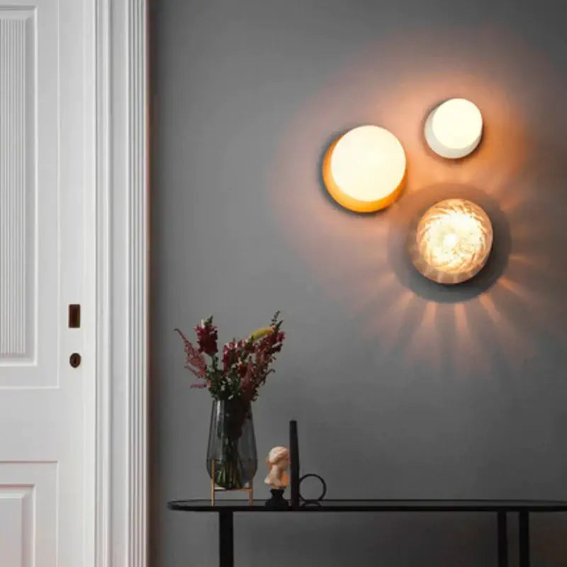 Three warm glowing decorbites glass ball ceiling lamps with nordic minimalist round glass ball design on gray wall