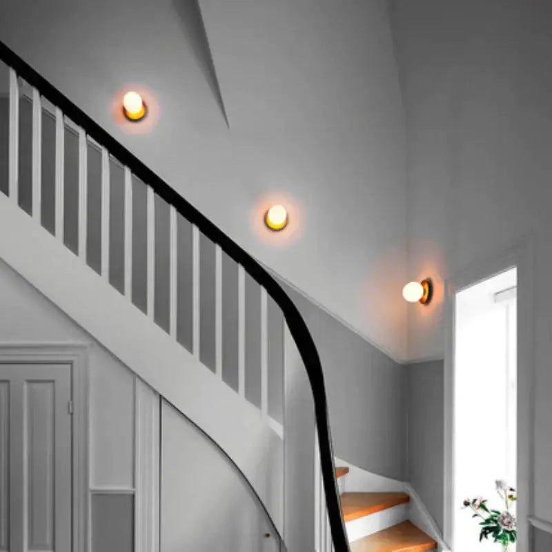 Three warm-toned DecorBites glass ball ceiling lamps illuminate the staircase with a Nordic minimalist design