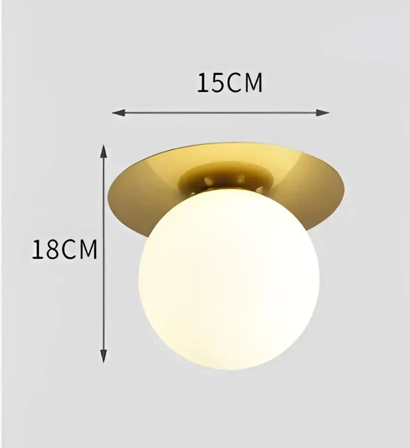 A decorbites glass ball ceiling light fixture with a brushed gold base and frosted white glass globe for bedroom use