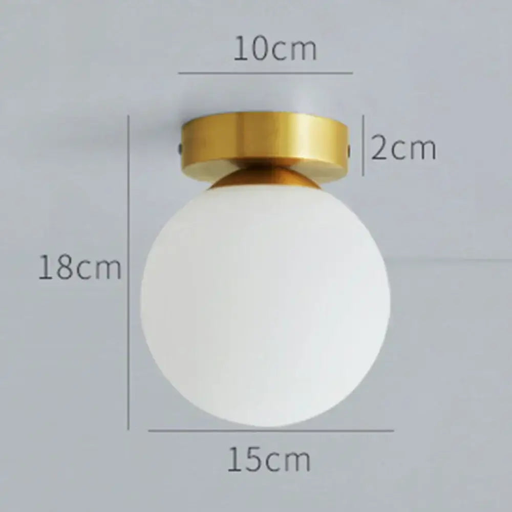 A sleek decorbites glass ball ceiling light with a frosted white glass ball shade and polished brass mounting ring