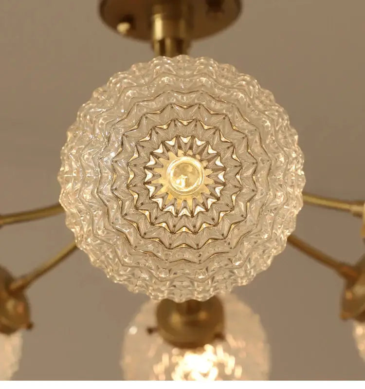 Clear intricately textured glass ball ceiling light with brass fixture by decorbites for modern nordic living spaces