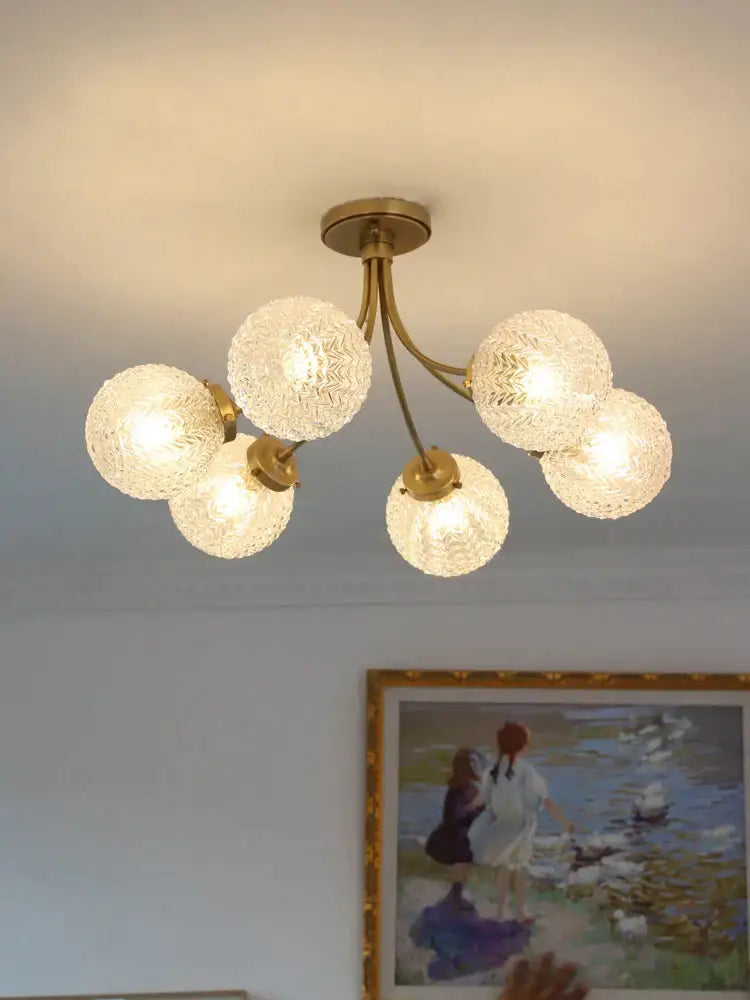 Brass-finished decorbites glass ball ceiling light with five textured frosted glass globes for modern living spaces