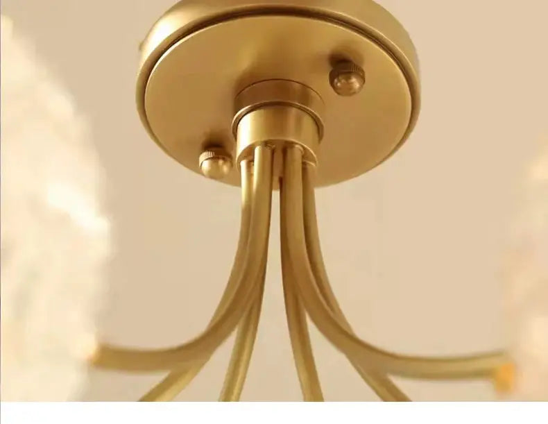 Gold-toned brass decorbites glass ball ceiling light with curved slender arms for modern living dining bedroom use