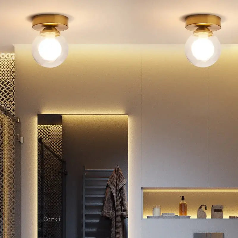 Two brass-finished decorbites glass ball ceiling lights with frosted glass globe shades for modern home decor