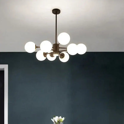 Modern brass-finished decorbites glass ball chandelier with multiple glowing white spherical glass globes for dining room lighting