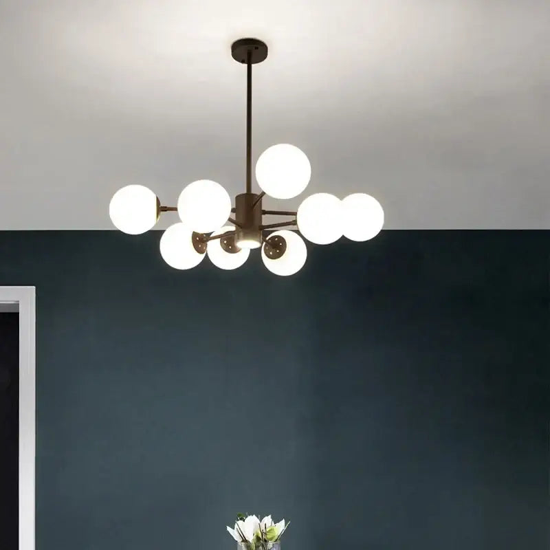 Modern brass-finished decorbites glass ball chandelier with multiple glowing white spherical glass globes for dining room lighting